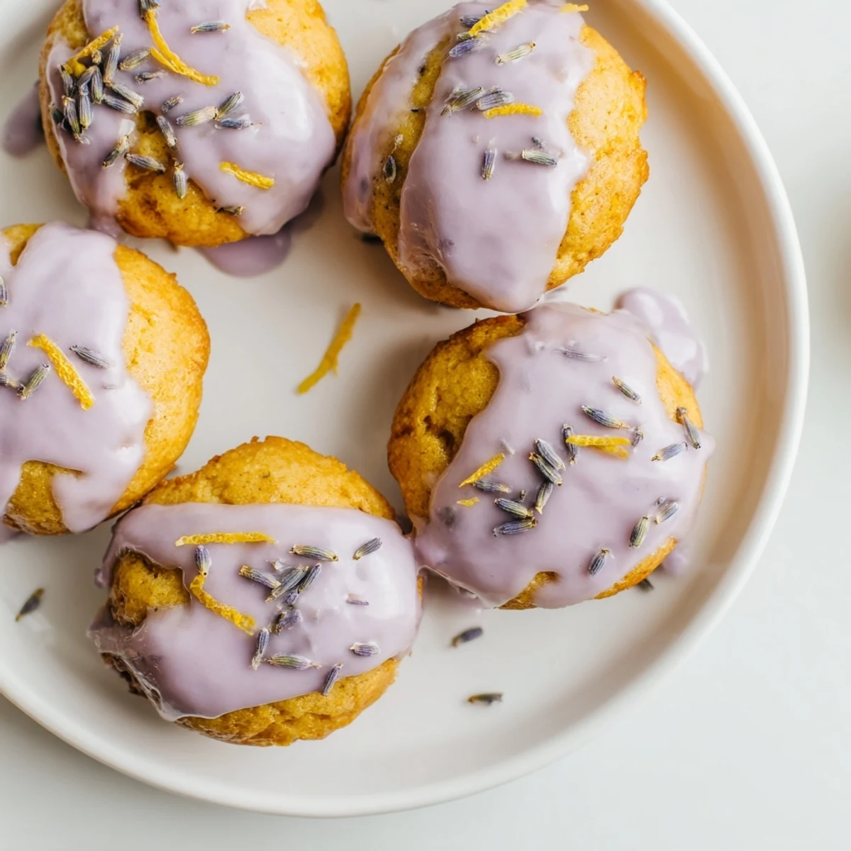 Freshly baked lemon mini cakes topped with smooth lavender icing and sprinkled with dried lavender buds