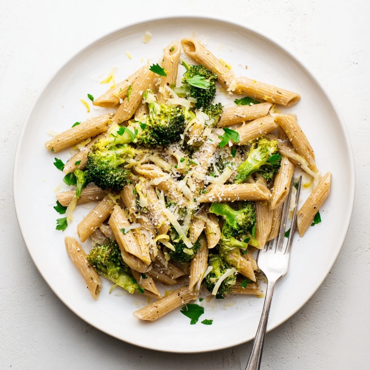 Plate of tender broccoli and al dente pasta drizzled with lemony olive oil sauce and red pepper flakes