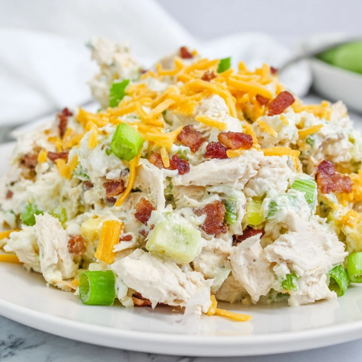Creamy jalapeno popper keto chicken salad with crispy bacon bits in white bowl