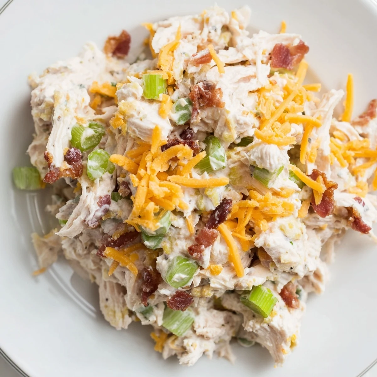 Spoonful of spicy low-carb jalapeno popper chicken salad loaded with cheese and fresh jalapenos