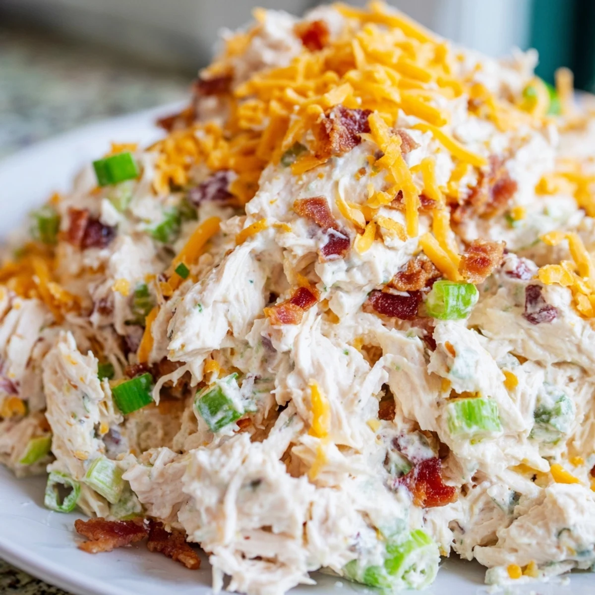 Keto chicken salad inspired by jalapeno popper dip topped with crumbled bacon and cheddar