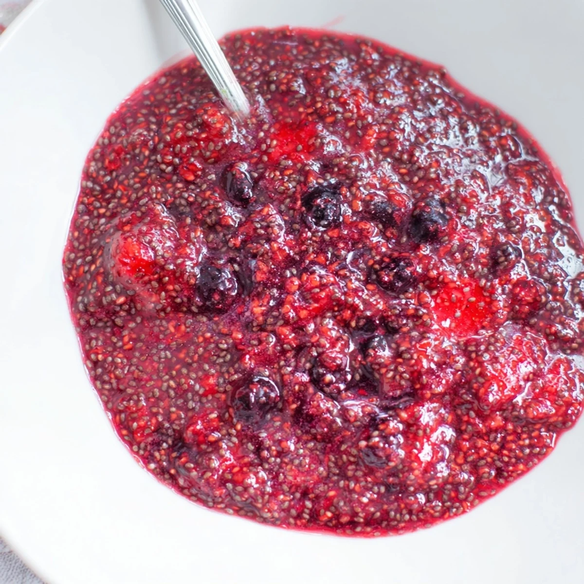 Thick purple easy berry chia seed jam spread generously on golden toasted sourdough bread