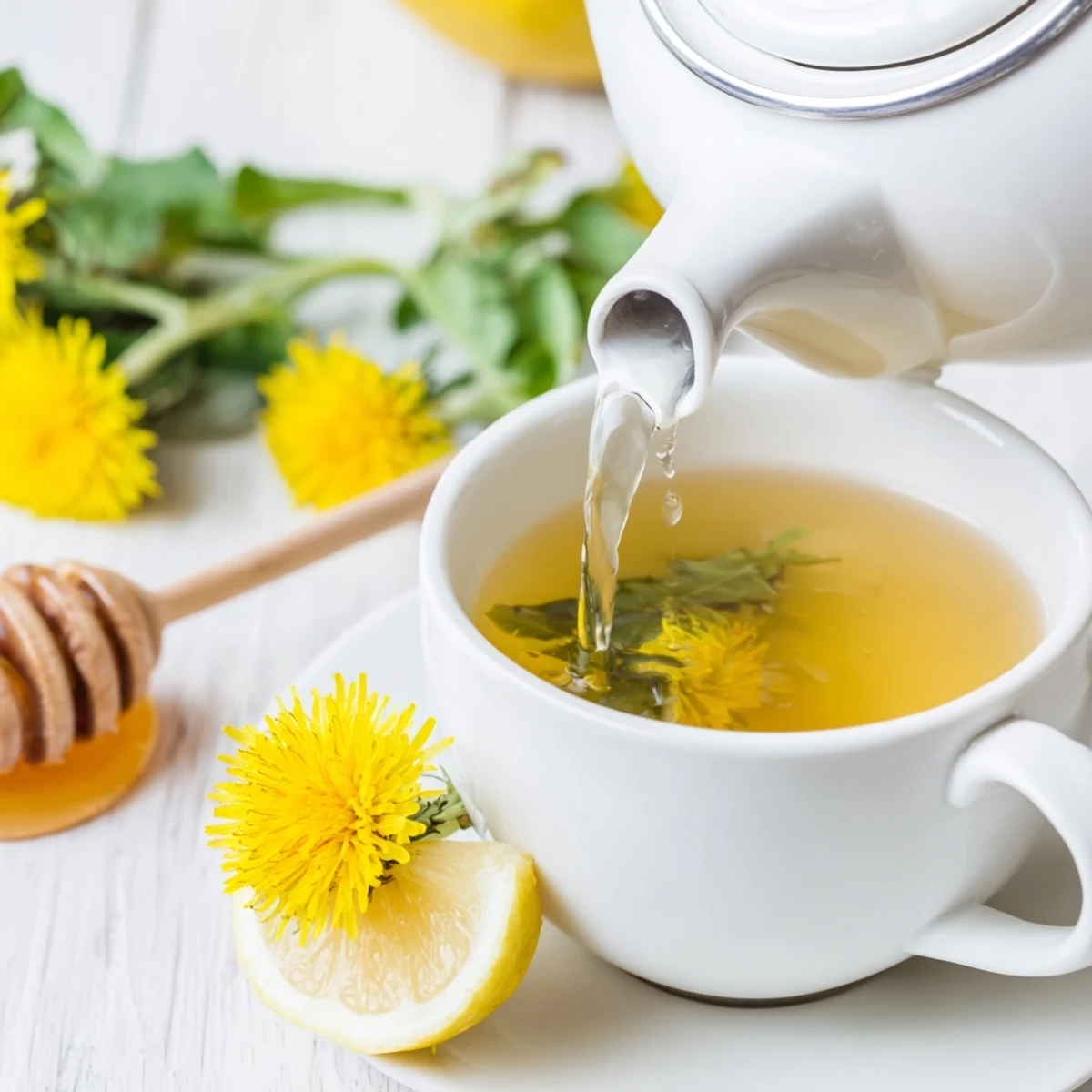 Clear glass mug of amber dandelion tea infusion resting on rustic kitchen counter