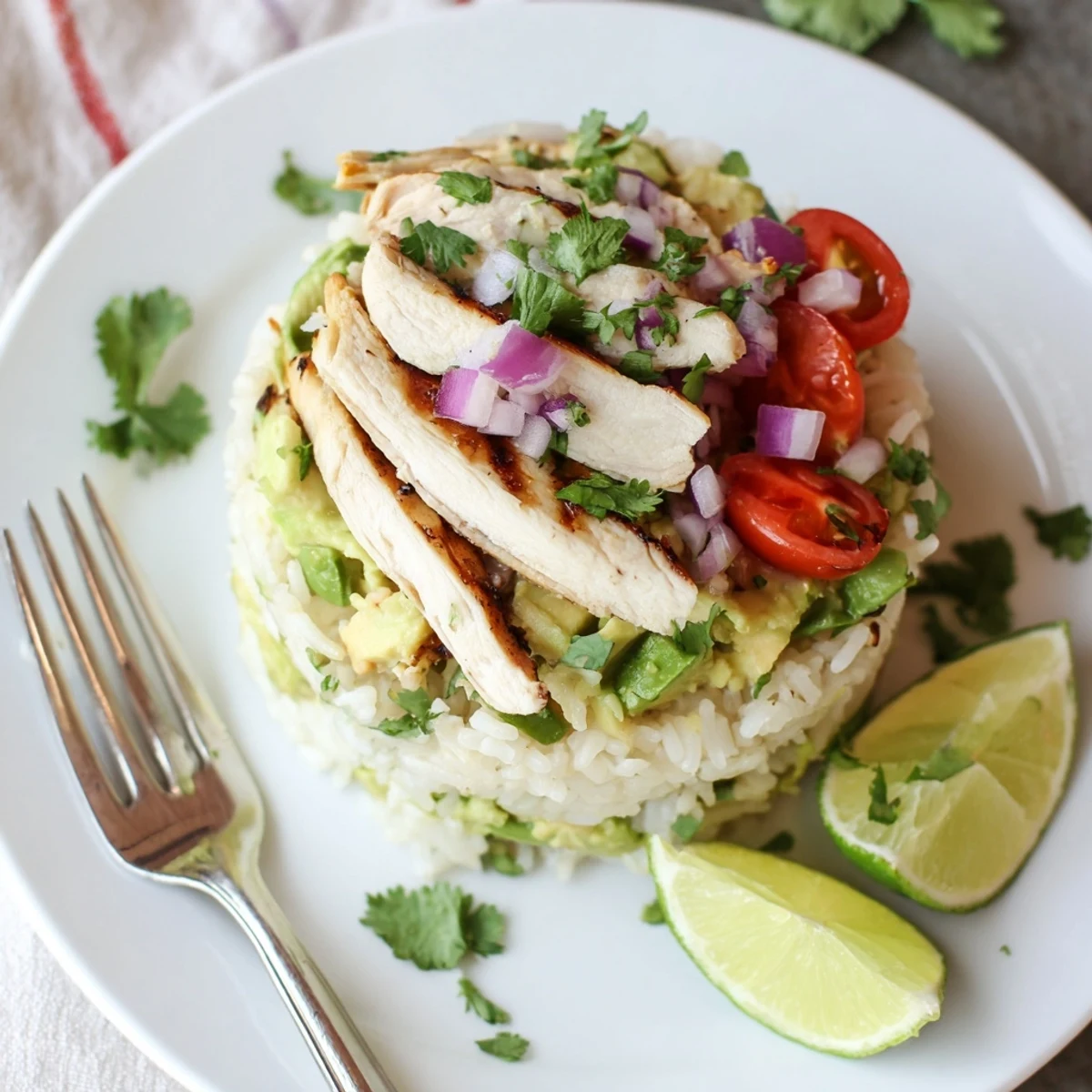Honey lime chicken avocado rice stack layered in a glass bowl with fresh cilantro garnish
