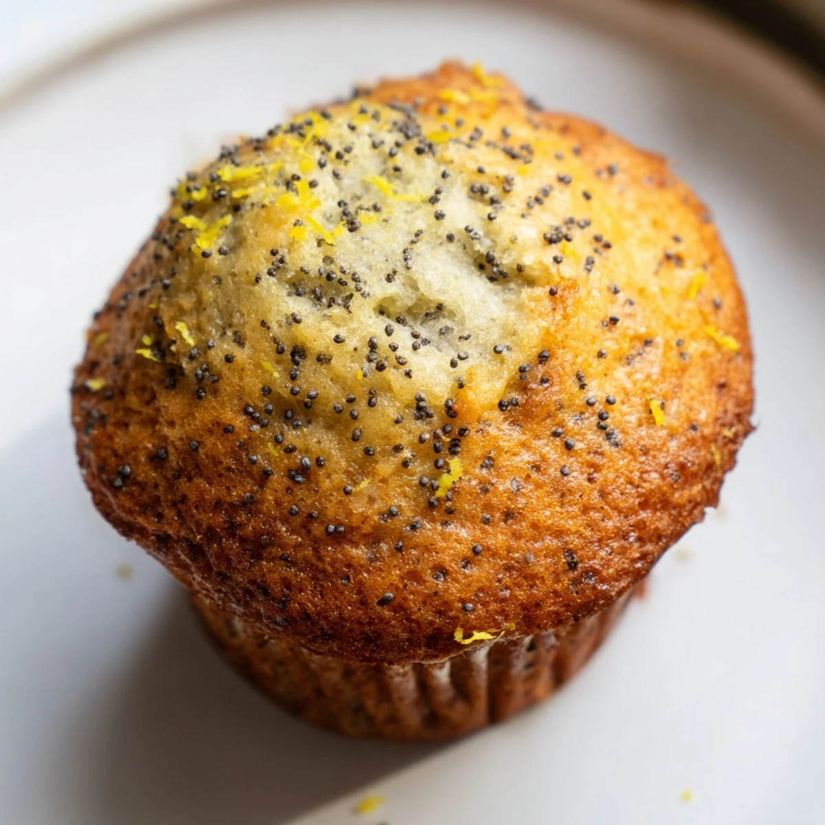 Golden lemon poppy seed muffins with domed tops fresh from the oven on a cooling rack