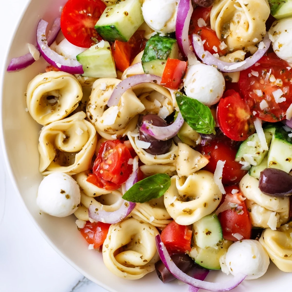 Colorful tortellini salad tossed with crisp vegetables and creamy mozzarella in zesty Italian dressing