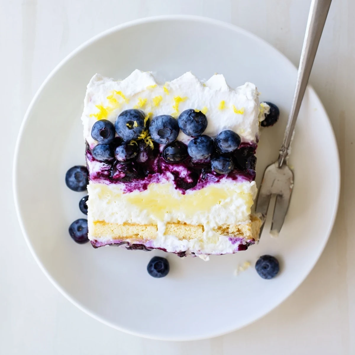 Slice of lemon blueberry lasagna recipe showing creamy layers and purple blueberry swirls