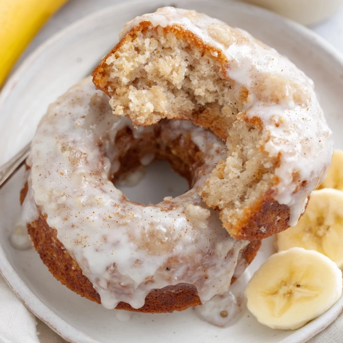 Close-up of sliced Banana Donuts revealing moist interior, cinnamon flecks, glaze.