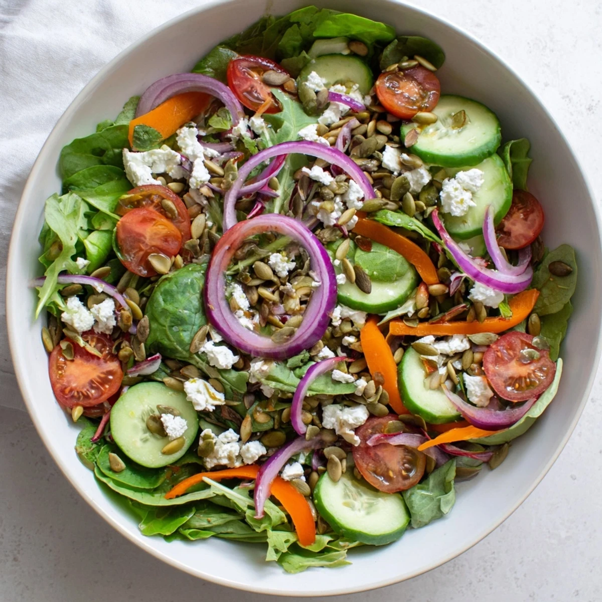 Colorful garden salad bowl featuring crisp mixed greens, cherry tomatoes, cucumber, and light vinaigrette dressing
