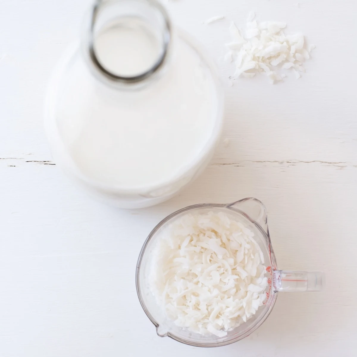 Smooth white homemade coconut milk being poured from a glass mason jar