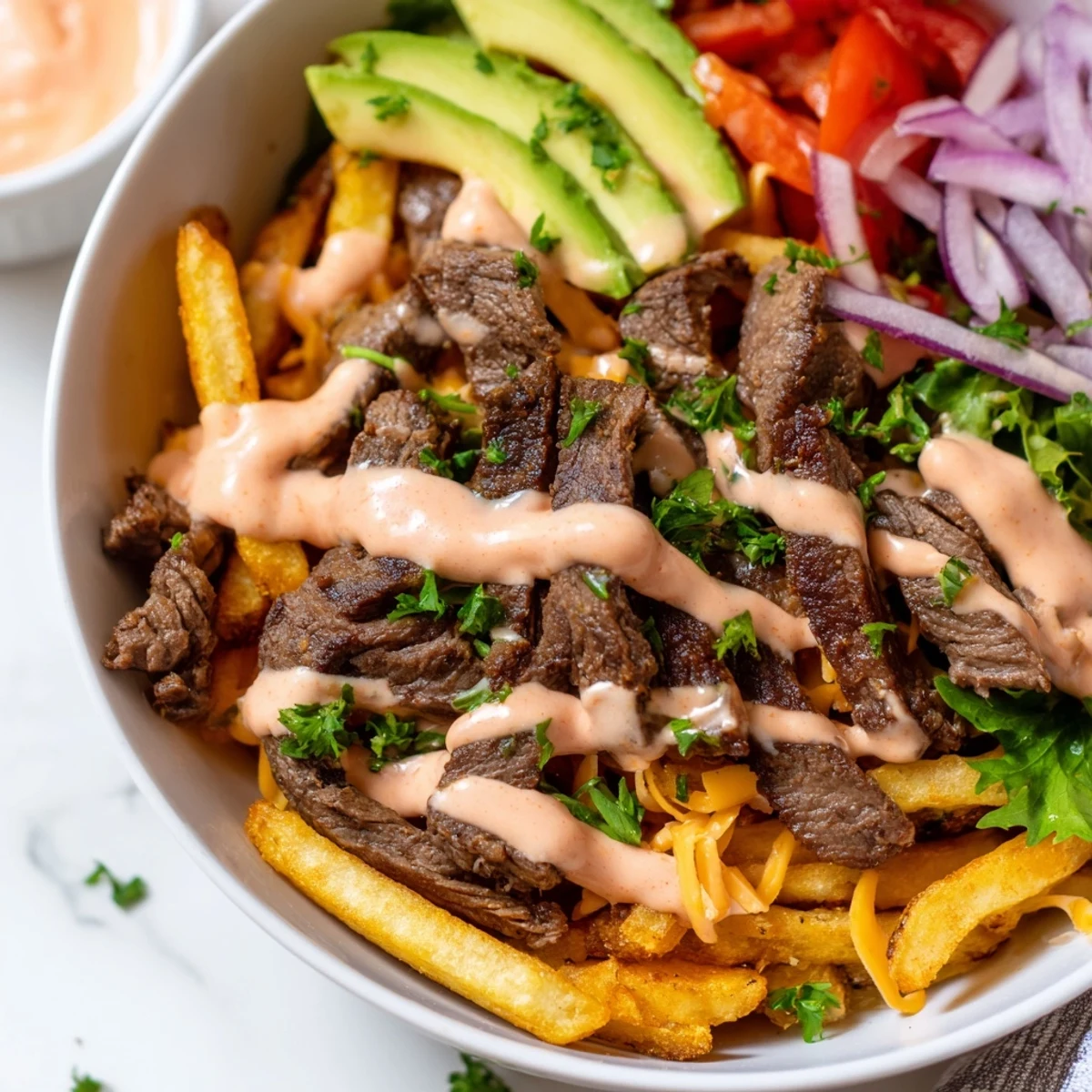 Steak strips crispy fries bowl loaded with golden potatoes and fresh vegetables