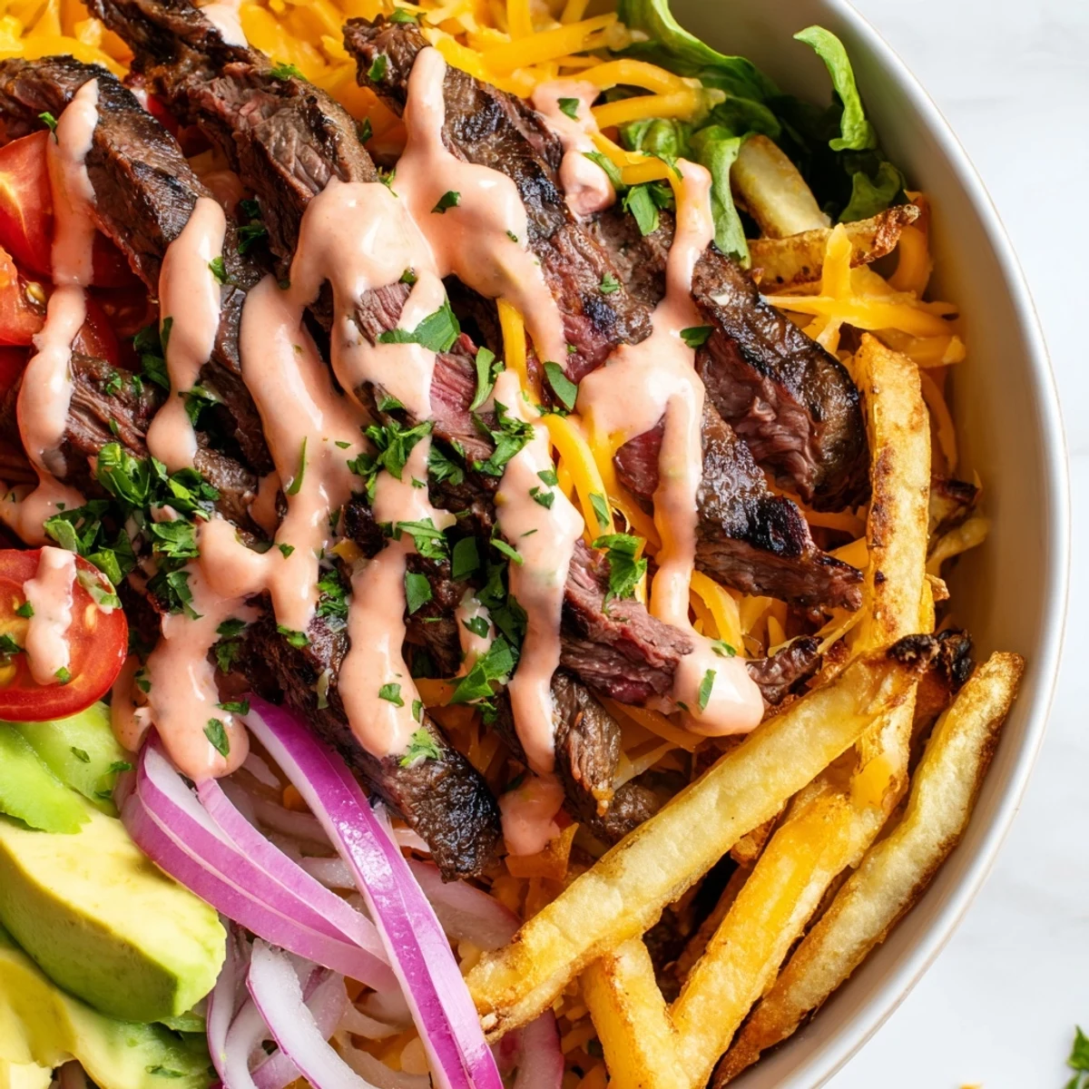 Hearty steak strips crispy fries bowl drizzled with smoky zesty sauce