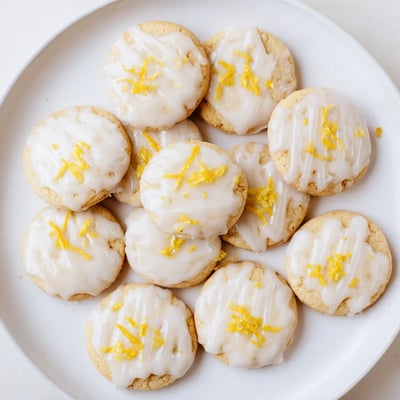 Buttery Italian Limoncello cookies topped with sweet glaze and fresh lemon zest garnish