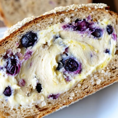 Freshly baked blueberry lemon cream cheese sourdough bread with golden crust and zesty citrus flecks throughout