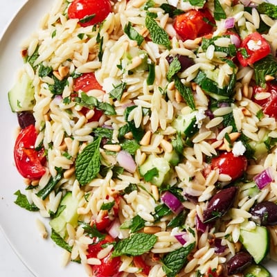 Hearty bowl of Mediterranean orzo power salad with crisp cucumbers and Kalamata olives