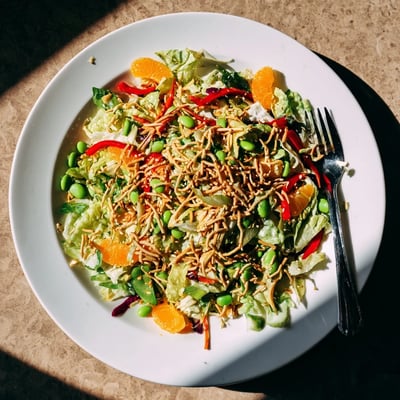 Mandarin Sesame Crunch Salad with juicy orange segments, crisp vegetables, and a glossy sesame ginger dressing